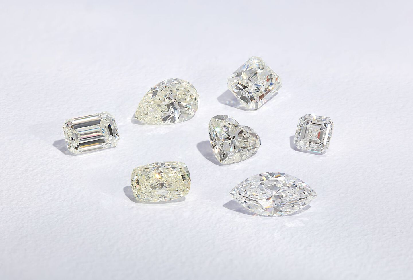Loose diamonds in various shapes against a gray background